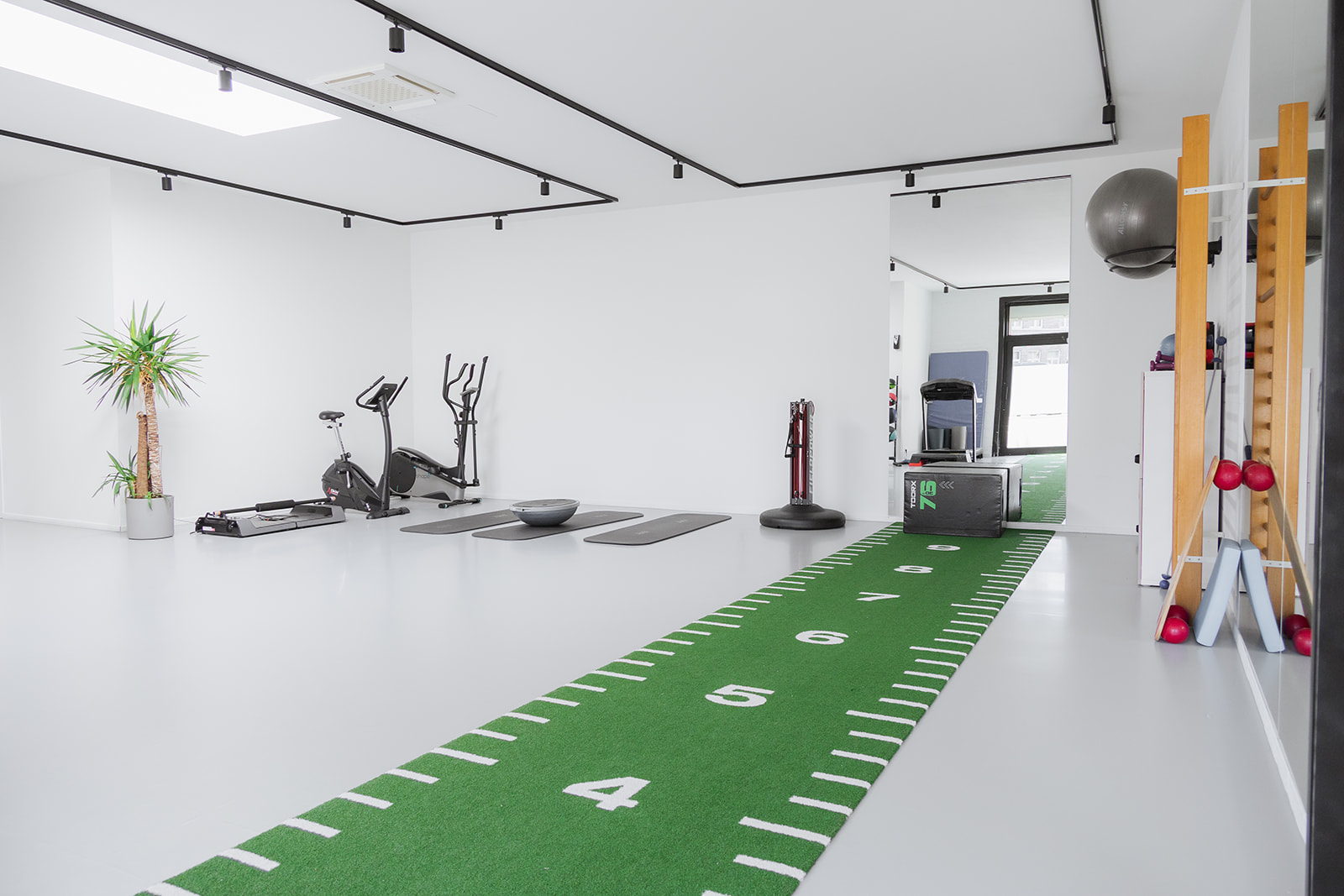Oefenruimte met kunstgras en revalidatietoestellen