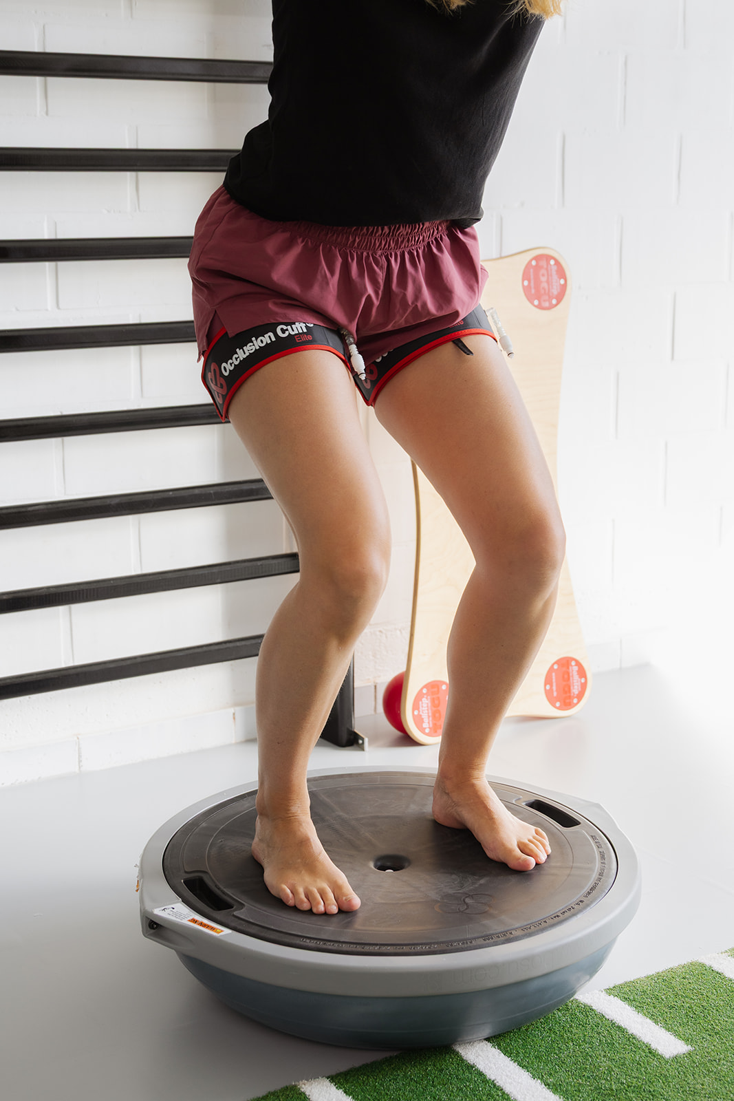 Blood flow restriction training met occlusion cuffs op een balanskussen